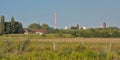 Nature reserve of Rieme, with industrial chimney and wind turbines and church tower in the distance