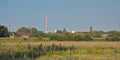 Nature reserve of Rieme, with industrial chimney and wind turbines and church tower in the distance