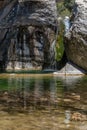 Nature with a river of mineral water with a waterfall and surrounded by gray rocks and green vegetation and plants Royalty Free Stock Photo