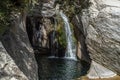 Nature with a river of mineral water with a waterfall and surrounded by gray rocks and green vegetation and plants Royalty Free Stock Photo