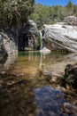 Nature with a river of mineral water with a waterfall and surrounded by gray rocks and green vegetation and plants Royalty Free Stock Photo