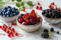 Nature's jewels: A trio of bowls showcasing blueberries, red currants, and blackberries on a simple white wooden Royalty Free Stock Photo