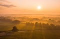 Nature scenery with sun rising above country covered in fog. Royalty Free Stock Photo