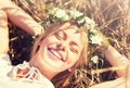 Happy woman in wreath of flowers lying on straw Royalty Free Stock Photo