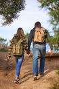 In nature together. Rear view shot of a young couple walking down a hiking trail. Royalty Free Stock Photo
