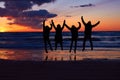 Nature is vitalizing. Silhouette of a group of people jumping on the beach at sunset. Royalty Free Stock Photo