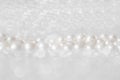 Nature white string of pearls on a sparkling background in soft focus, with highlights Royalty Free Stock Photo