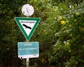 Nature and wildlife protection green triangular sign and plaque on the pole in lush green area Royalty Free Stock Photo