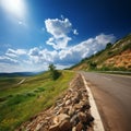 Natures beauty Road ascending towards hill under a sunny sky