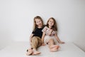 Naughty boy hugs girl, she leans away. Siblings sitting together on a table. Royalty Free Stock Photo