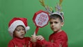 Naughty brothers inviting santa to come. Dancing and grabbing the sign