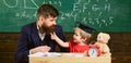 Naughty child concept. Father with beard, teacher teaches son, little boy. Kid cheerful distracting while studying Royalty Free Stock Photo