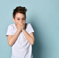 Naughty funny boy covering mouth with both hands trying to keep silence, save secret or laughing about something. Royalty Free Stock Photo