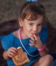 A naughty girl eats jam with a pin off a bun. Delicious sweet pastries in children `s hands Royalty Free Stock Photo