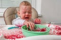 Naughty messy dirty baby is eating with hands Royalty Free Stock Photo