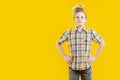 Naughty teenager. Restless schoolboy. Cute boy with a funny face and unkempt hairstyle on a yellow background