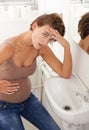 Nausea, pregnant woman and morning sickness in basin unhappy and hand on stomach for discomfort. Exhausted, moody and