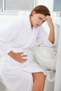 Nausea, pregnant woman and morning sickness in bathroom, unhappy and hand on stomach. Mirror reflection, moody and