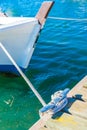 Nautical boat rope tied on cleat on wooden pier Royalty Free Stock Photo