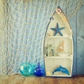 Nautical boat shape shelves and nautical life style objects on wooden table. vintage filtered