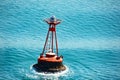 Nautical buoy floating on the blue sea water with a seagull Royalty Free Stock Photo