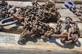 Nautical chains and clips rusted and weathered textured metal resting on a seaside dock detail