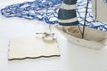 nautical concept image with white decorative sail boat and empty wooden board over white table. Royalty Free Stock Photo