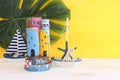 Nautical concept with sea life style objects as boat, driftwood beach houses, seashells and starfish over wooden table and yellow Royalty Free Stock Photo