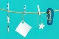 Nautical concept with sea lifestyle decorations hanging on rope with turquoise. Sea toys flip-flop, seastars