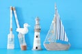 nautical concept with white decorative seagull bird, lighthous, wooden oars and boat oars over blue background. Royalty Free Stock Photo
