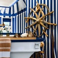 Nautical Escape: A coastal-themed bathroom with navy blue and white stripes, seashell decor, and a vintage ship wheel, evoking a