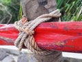 Nautical knot in red wood mast tied to palm tree trunk. Tropical and Caribbean culture. Detail of traditional boats. Safety and Royalty Free Stock Photo