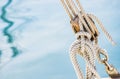 Nautical maritime background, sailboat wooden pulley with ropes and sea water background