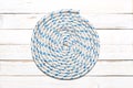 Nautical rope in spiral shape on a white wooden  deck with copy space for your text Royalty Free Stock Photo