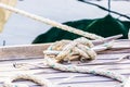 Nautical rope tied on cleat at wooden deck of boat Royalty Free Stock Photo