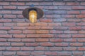 Nautical style outdoor metal lantern illuminating red brick wall