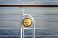 Nautical white outdoor deck lamp with brass metal fitting aboard cruise ship.