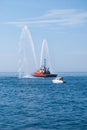 Naval vessel of firefighters with high splashes of sea water