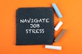 Navigate Job Stress. Text on a stone surface. Pieces of chalk on an orange background
