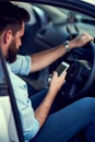 Navigating is easy when you have a phone. a unrecognizable man using his phone while driving to a destination.