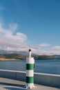 Navigation beacon on the pier against the backdrop of mountains