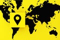 Navigation, travel or route destination concept. Location map pin symbol on a yellow cube block on world map Royalty Free Stock Photo
