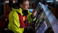 Navigator. pilot, captain as part of ship crew performing daily duties with VHF radio, binoculars on board of modern ship with