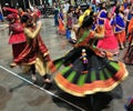 Group of Men and women are dancing in action. Enjoying Hindu festival of Navratri Garba wearing traditional consume.