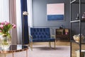 Navy blue armchair next to lamp in sophisticated apartment inter Royalty Free Stock Photo