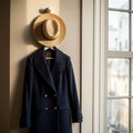 Navy Blue Coat and Straw Hat by a Window Royalty Free Stock Photo