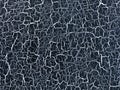 Navy blue decorative plaster with aging effect. Black background with white cracked paint