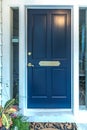 A navy blue front door of a commercial location building with a welcome mat Royalty Free Stock Photo