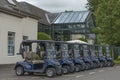 Navy blue golf buggies lined up outside Gleneagles golf course clubhouse