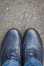 Navy blue leather shoes on asphalt road or footpath. Male footwear